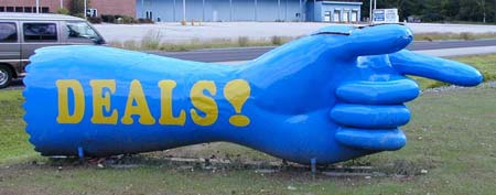 Photo of an arm sculpture with DEALS! painted on it