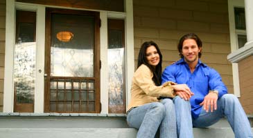 Photo of couple sitting on front porch in front of new front door