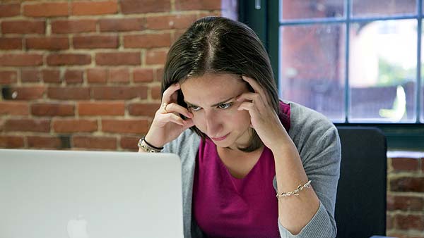 Photo of a woman scowling at your laptop computer