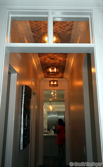 Photo of hallway with tall ceilings and a brick treatment by Tre Pryor
