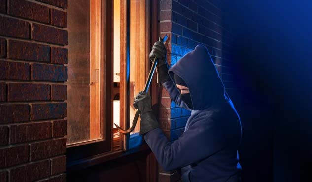 Image of criminal breaking into a home
