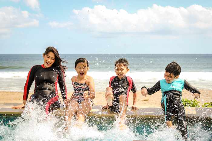 Photo of a mother and children splashing in the pool on a family vacation - 4 Ways to Prepare Your Home Before Vacation