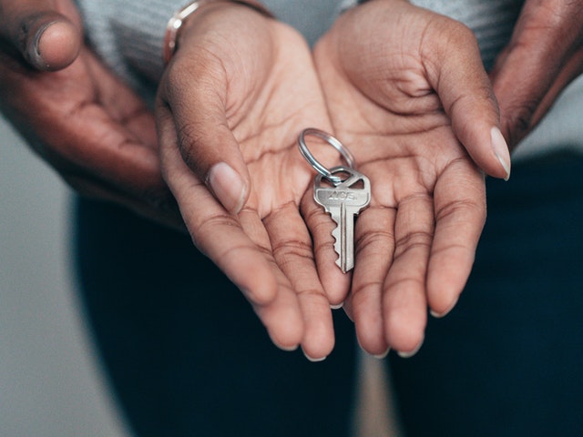 Photo of a couple with hands holding keys