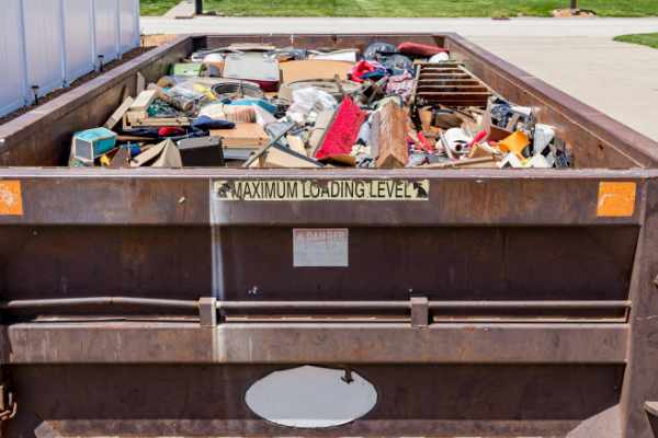 Phot of a dumpster fill with trash and junk