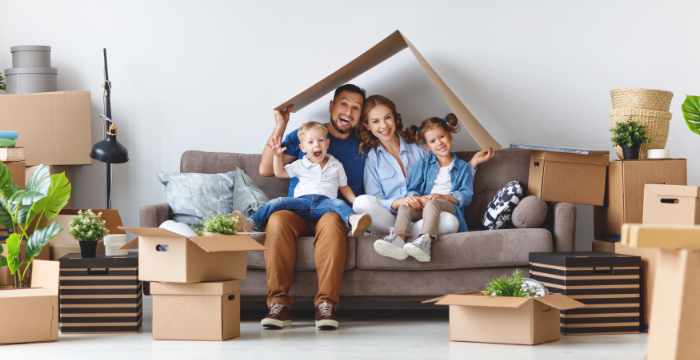 Photo of a family with moving boxes sitting on a couch