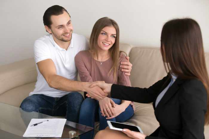 Photo of a happy couple with a real estate agent
