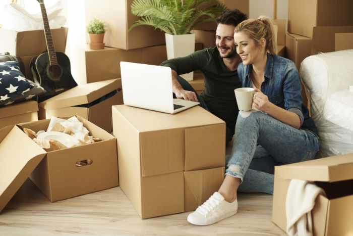 Photo of a couple in their new home full of moving boxes