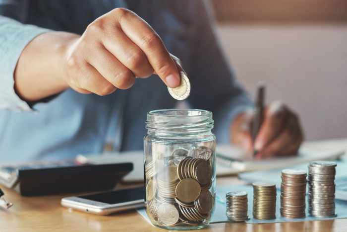 Photo of a man saving coins in a jar