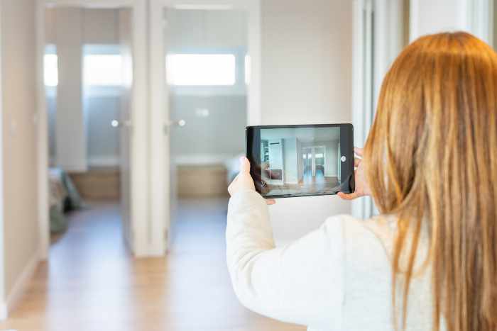 Photo of a woman recording her home with a tablet computer