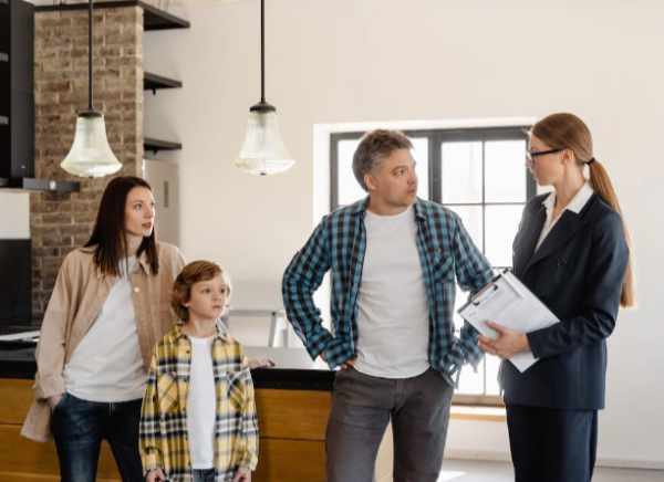 Photo of a real estate agent showing a home to a family