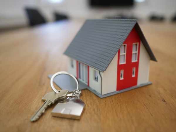 Photo of a tiny toy house and house keys