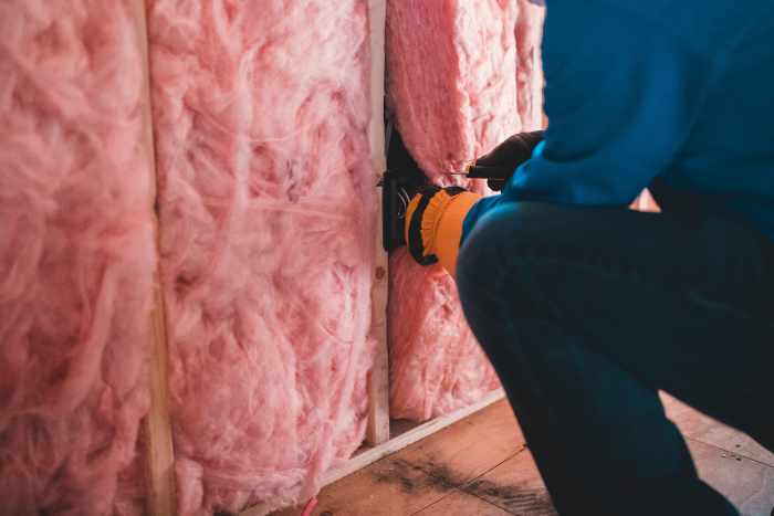 Photo of a worker installing insulation