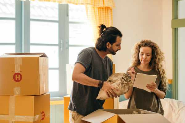 Photo of couple who are packing boxes - Tips to manage the stress of moving