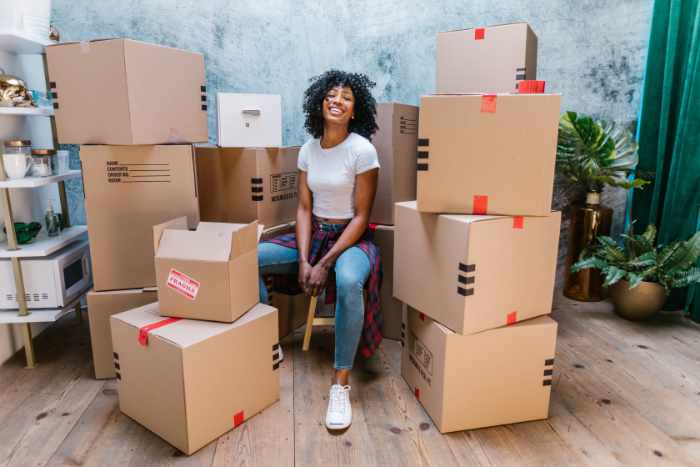 Photo of a woman with moving boxes - Comparing Long-Distance Movers