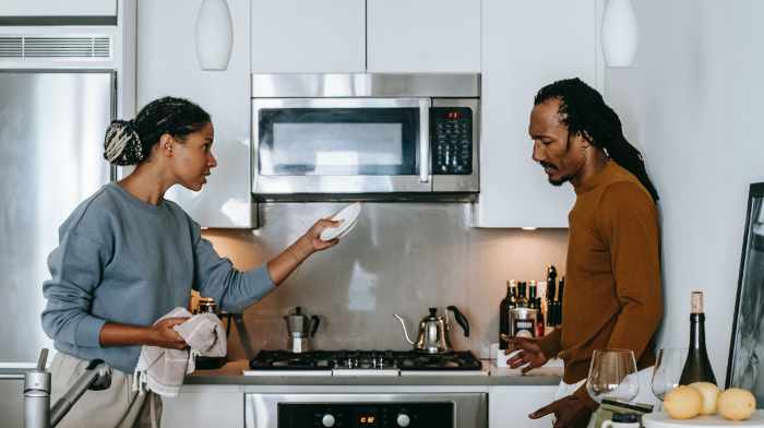 Photo of a couple having an argument in their kitchen. - What Happens to Real Estate Assets During Divorce?