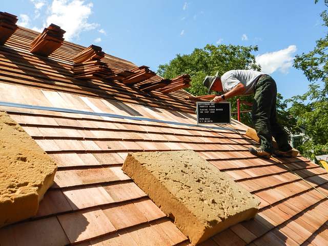 Photo of a man installing a cedar roof on a house