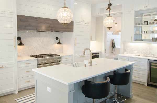 Photo of a new, white kitchen with wood accent hood