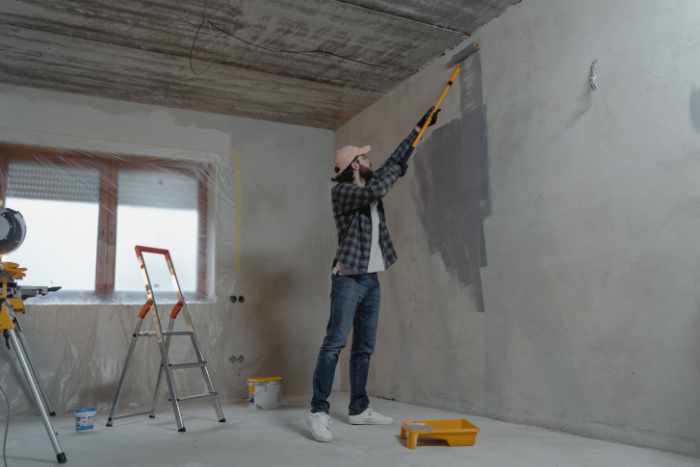 Photo of a home remodeling service company contractor painting a wall - 9 Benefits of Hiring a Home Remodeling Service