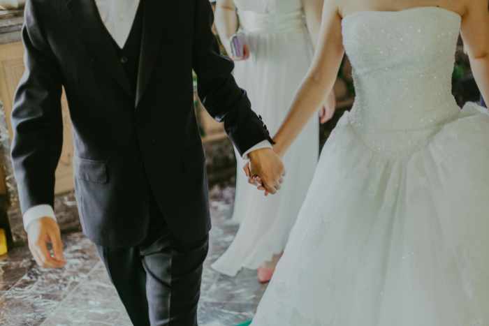 Photo of a wedding couple holding hands - Experts Share How to Turn Your Home Into a Dream Wedding Venue