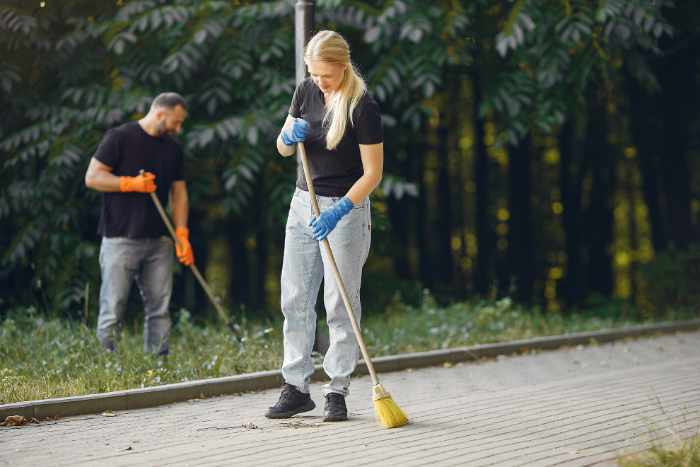 Photo of a couple sweeping their driveway