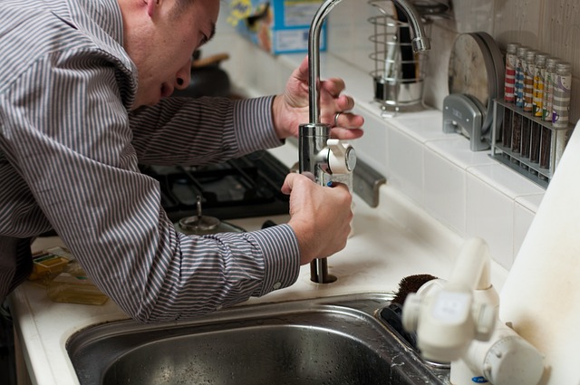 Photo of a plumber installing a kitchen faucet - Outsmart Plumbing Disasters with This Handy Plumbing Checklist