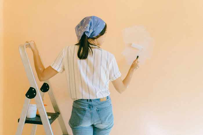 Photo of a woman painting a wall - Color Harmony: Choosing the Perfect Paint Palette for Your Home