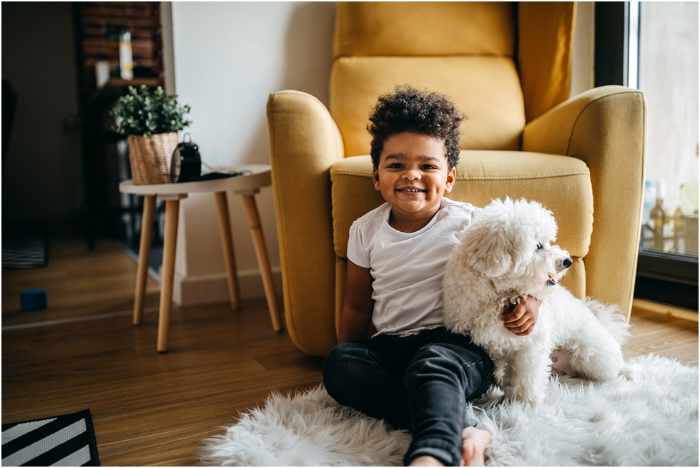 Photo of a young boy with his dog sitting in the living room - Kid and Pet-Friendly Home Design Materials: Practical and Stylish Solutions