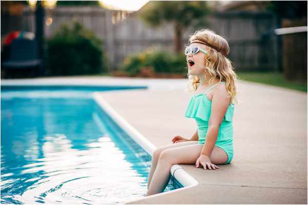 Photo of a little girl sitting with her feet in a swimming pool - Avoiding Costly Backyard Mistakes: Smart Tips for Homeowners