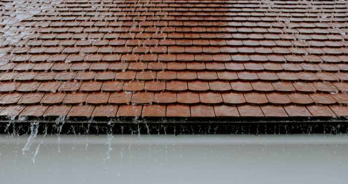 Photo of a roof with rainwater coming off - Why Quality Roofing is Key to Protecting Your Home Investment