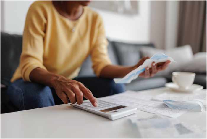 Photo of a woman using a calculator with receipts - Demographic Shifts and Their Influence on Mortgage Trends