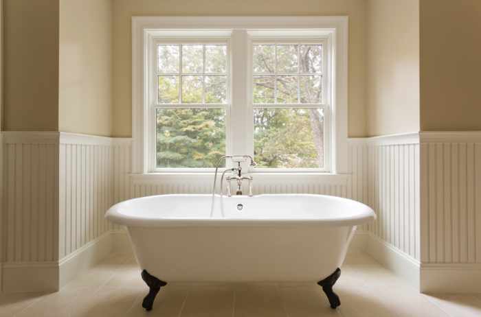 Photo of a bathtub under a window - Transforming Bathrooms into Sensory Havens: Combining Scent, Sound, And Light