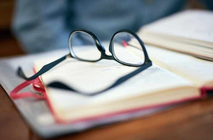 Photo of some books and journals with a pair of glasses on top - How to File a Proper Home Insurance Claim: A Step-By-Step Guide