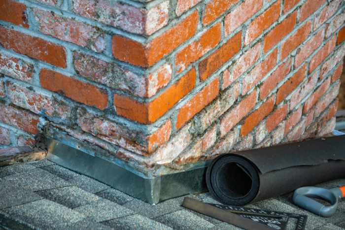 Photo of a house with a shingle roof chimney with flashing - How Roof Repair Services Can Protect Your Home From Costly Damage