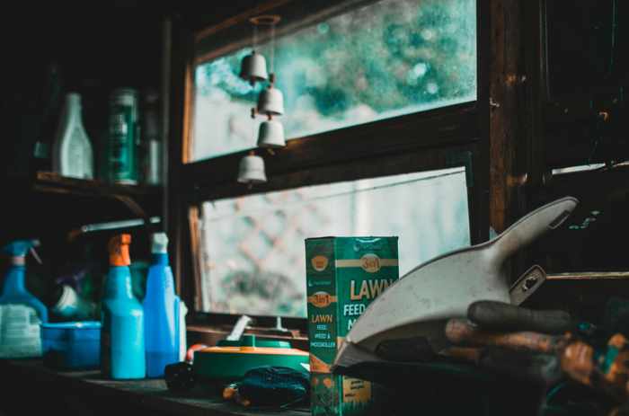 Photo of a garage counter with various products and cleaners - Tackling Garage Clutter Hotspots: How To Keep Your Space Functional And Organized