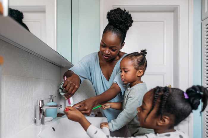 Photo of a mother with her two children brushing teeth in their bathroom - Creating the Perfect Family-Friendly Bathroom: 6 Tips to Make It Happen