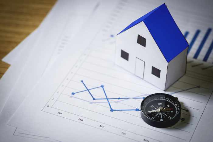 Photo of a small house and a compass on a paper with charts - How the Louisville Real Estate Market Compares to Other US Cities