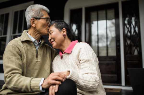 Photo of a couple holding hands on their front porch - A New Chapter At Home: Remodeling After the Empty Nest