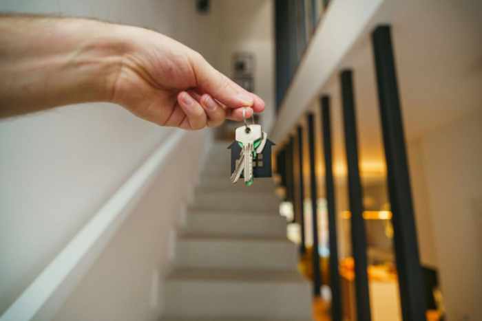Photo of someone holding house keys going up a staircase - What Landlords and Homeowners Should Prioritize for Long-Term Property Health