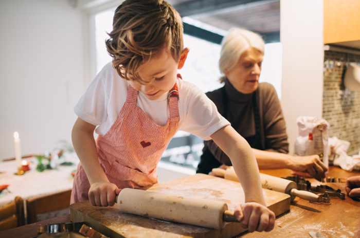 Photo of a boy rolling dough with his grandmother in the kitchen - A Grandkid-Proofing Guide for Your Home