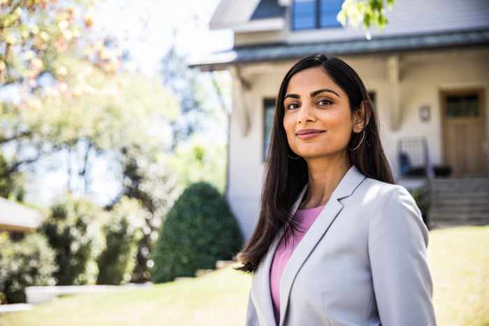 Photo of a woman in front of her house - The ROI Behind Real Estate Visual Strategy